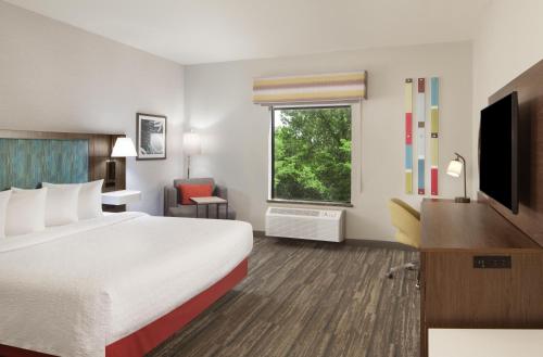 a hotel room with a large bed and a window at Hampton Inn & Suites Natchez in Natchez