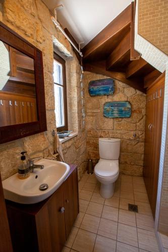 a bathroom with a toilet and a sink at Eco Stone Villa with Private Pool and Jacuzzi in Kalandra