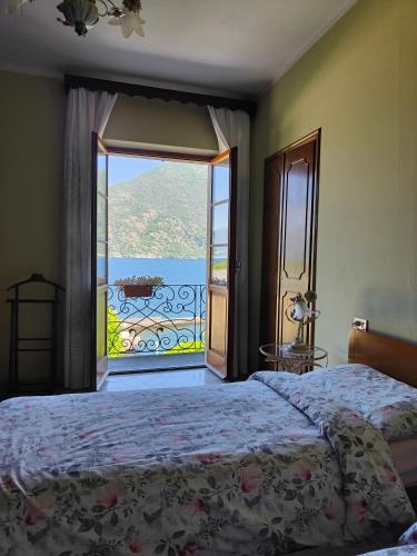 a bedroom with a bed and a large window at Casa Farfalla in Cannobio