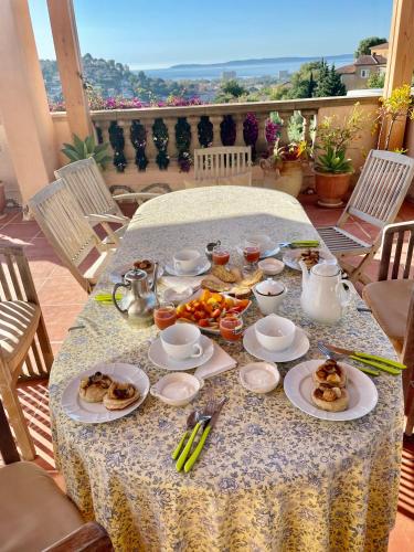 a table with plates of food on a patio at Les Terrasses de Lô in Bormes-les-Mimosas