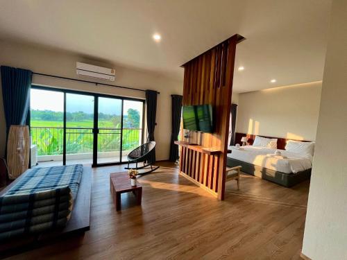 a bedroom with a bed and a tv and a couch at Zenery Lake Resort in Ban Don Klang