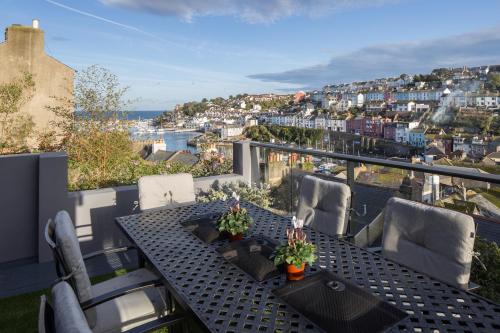 a patio with a table and chairs on a balcony at Driftwood B&B in Brixham
