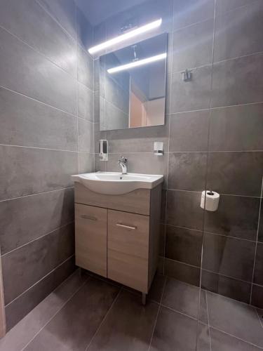 a bathroom with a sink and a mirror at Korina's Apartments in Ipsos