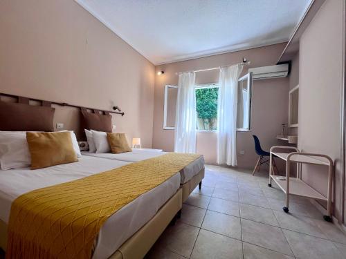 a hotel room with two beds and a window at Korina's Apartments in Ipsos