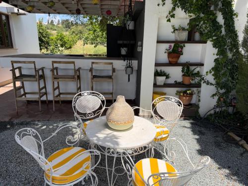 a table with chairs and a vase on it at Villa Grand Zeus in Anoyira