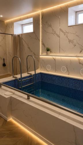 a bathroom with a bath tub with blue tiles at Everest in Zyryanovsk
