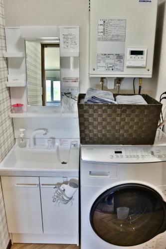 a laundry room with a washing machine and a sink at Retreat Furano A in Furano