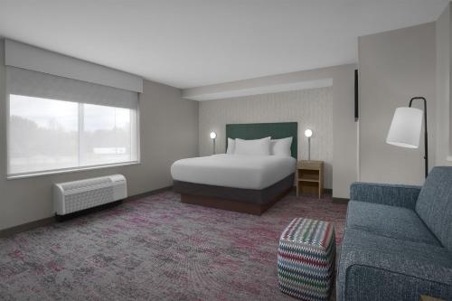 a hotel room with a bed and a couch at Home2 Suites by Hilton Chelmsford Lowell in Chelmsford
