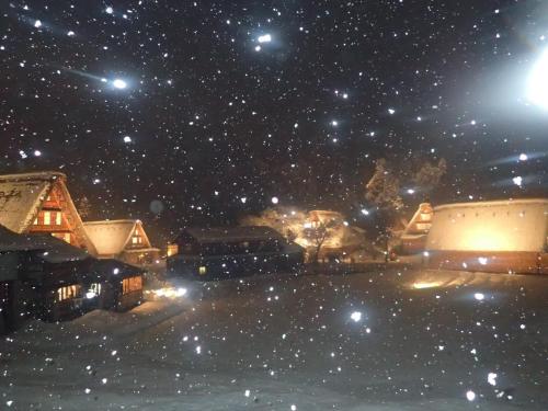 a snowy city at night with stars in the sky at Guest House YAMASHITA-YA in Nanto