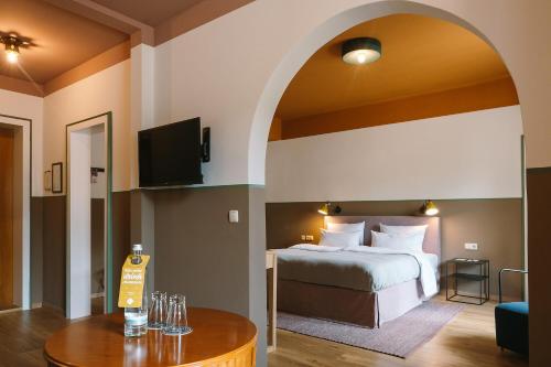 a hotel room with a bed and a table at HENRI Hotel Garmisch-Partenkirchen in Garmisch-Partenkirchen