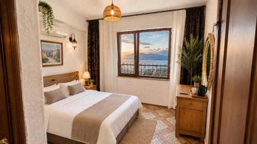 ein Schlafzimmer mit einem Bett und einem großen Fenster in der Unterkunft Lithos Assos in Ayvacık