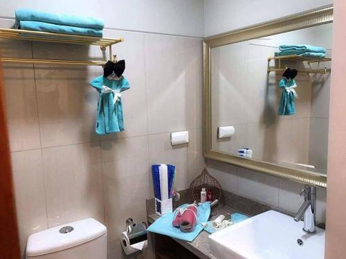 W łazience znajduje się umywalka, lustro i toaleta. w obiekcie Tiffany Room At Shell Residences w mieście Manila
