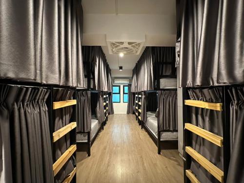 a hallway with black bunk beds in a room at Bangkok Sleep Nest in Sathani Ban Hua Mak
