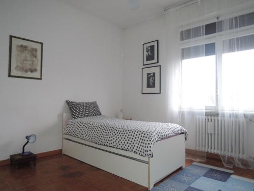 um quarto branco com uma cama e uma janela em NavigliCenter em Milão