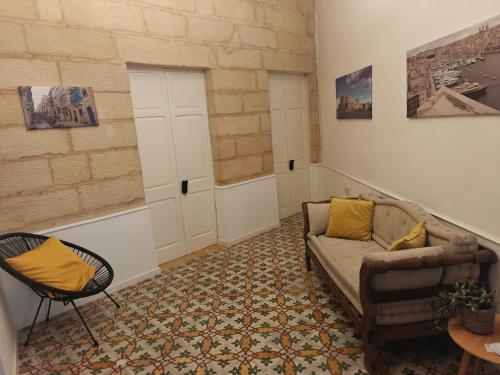 a living room with a couch and a chair at 3 Cities Heart 1 in Cospicua