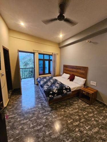 a bedroom with a bed and a ceiling fan at Sai Homestay in Mussoorie