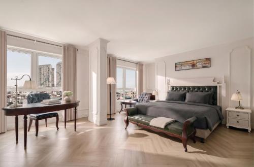 a bedroom with a large bed and a desk and a table at M Village Hotel Long Biên, a brand of Modern Village Lifestyle in Hanoi