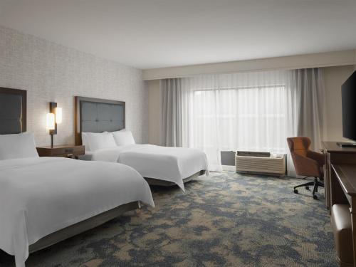 a hotel room with two beds and a desk at Hampton Inn & Suites Braselton in Braselton