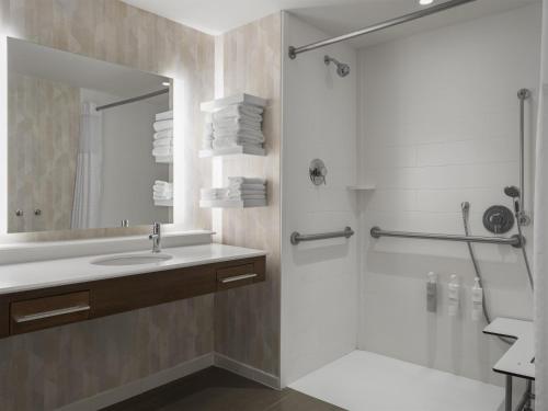 a bathroom with a shower and a sink and a mirror at Hampton Inn & Suites Braselton in Braselton
