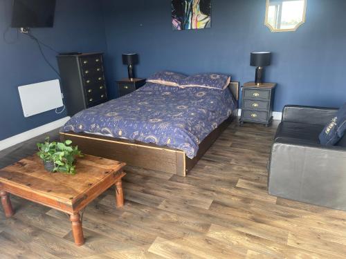 a bedroom with a bed and a table and a couch at Springwood cabin in Kirkhamgate