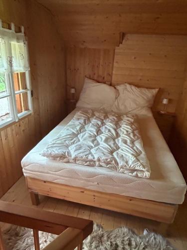 a bed in a wooden room with a bed frame at HeinrichH in Teuchl