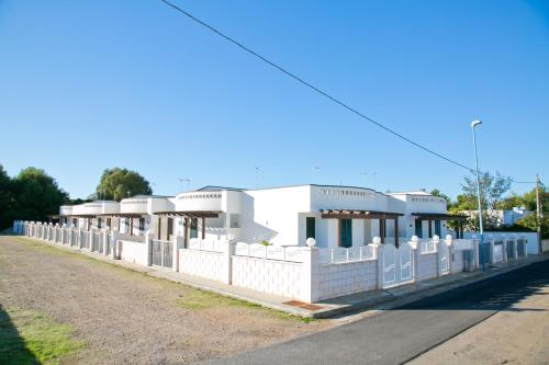 a white fence in front of a building at Complesso Gardencasa in Torre Suda