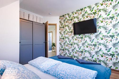 a bedroom with a bed and a tv on a wall at BORG VendégHázak - Tiszakécske in Tiszakécske