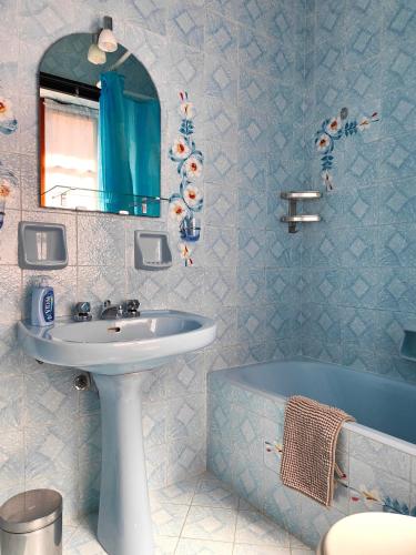 a bathroom with a sink and a tub and a mirror at Casa Farfalla in Cannobio