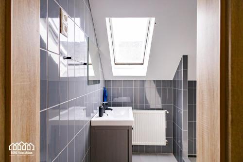 a bathroom with a sink and a mirror and a window at BORG VendégHázak - Tiszakécske in Tiszakécske