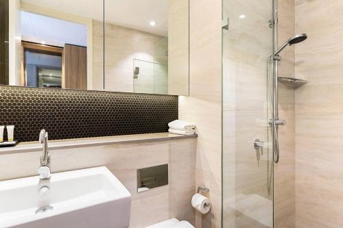 a bathroom with a sink and a glass shower at Quality Hotel Rules Club Wagga in Wagga Wagga