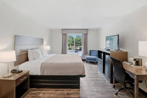 a hotel room with a bed and a desk and a desk at Quality Inn Duluth - Atlanta Northeast in Duluth