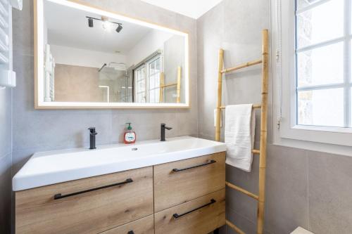 a bathroom with a white sink and a mirror at Gîte Ty Traon piscine partagée in Ergué-Gabéric