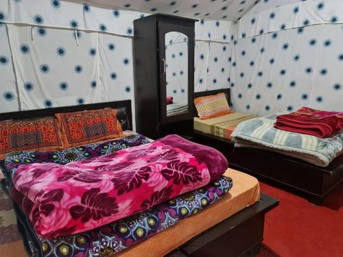 a room with two beds and a mirror at grand holiday camp in Sari