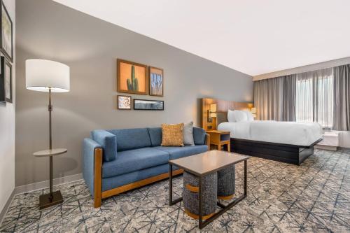 a hotel room with a couch and a bed at Country Inn & Suites by Radisson, Amarillo Central in Amarillo