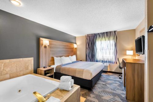 a hotel room with a bed and a bath tub at Quality Inn Fairfield in Fairfield