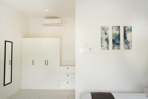 a white bedroom with white walls and a bed at THE SANDS LOMBOK in Mangsit