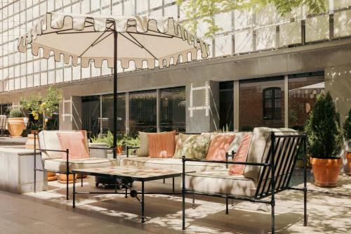 a patio with chairs and a table and an umbrella at Hospes Palacio de los Patos, a Member of Design Hotels in Granada