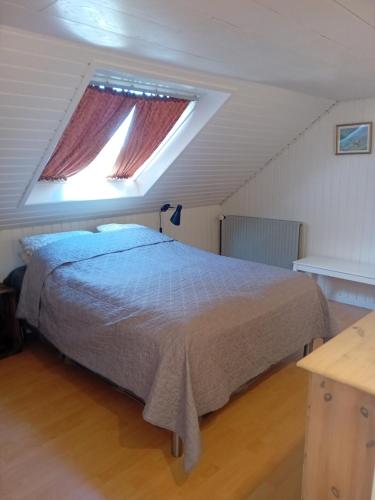 a bedroom with a bed and two windows at Heidis Loft in Vidstrup