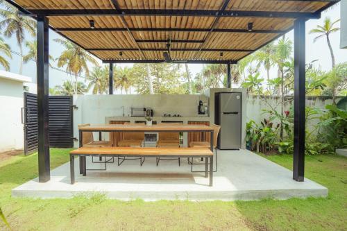 a picnic table under a pavilion with a wooden table at Air Villa in Ahangama