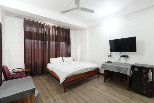 a bedroom with a bed and a flat screen tv at Hotel Zimin Ziro in Ziro