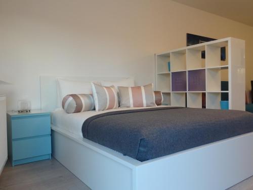 ポズナンにあるStudio POZのベッドルーム1室(大型ベッド1台、青いナイトスタンド付)