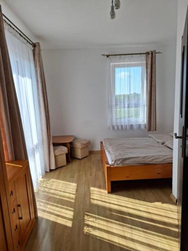a bedroom with a bed and a window at Pensjonat nad Stawem in Sarbinowo