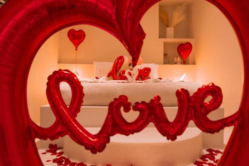 a bedroom with a bed with a love sign in a mirror at Suite Pacifique - Spa privatif avec baignoire in Calais