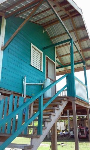 a blue house with a staircase leading up to it at Don Santiago Guesthouse Downtown in San Ignacio