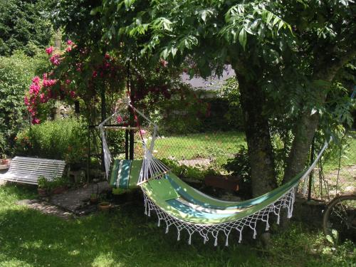 a hammock hanging from a tree in a garden at Maison Lacoste in Campan