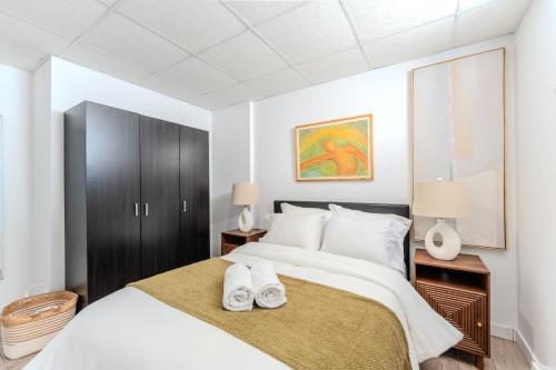 a bedroom with a large bed with two towels on it at Pretty Little House in Saguenay