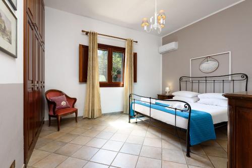 a bedroom with a bed and a chair and a window at SanVitoTour- Residence Il Baglio in San Vito lo Capo