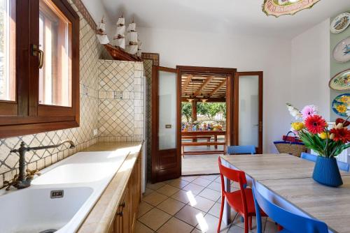 a kitchen with a sink and a table with chairs at SanVitoTour- Residence Il Baglio in San Vito lo Capo