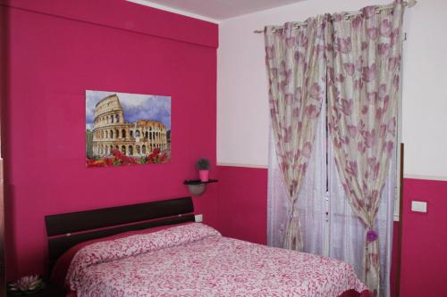 a pink bedroom with a bed and a building at Aracoeli in Rome