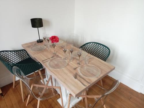 a wooden table with chairs and wine glasses on it at Appartement de cachet de 63m2 in Moulins